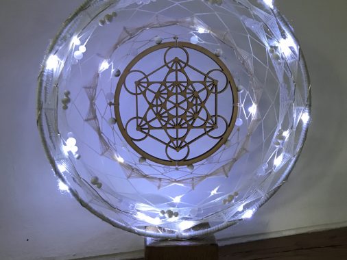 Le symbole de Métatron, représenté souvent par la Merkaba, incarne la géométrie sacrée et la connexion spirituelle, portant en lui l'énergie transcendantale et la guidance divine.